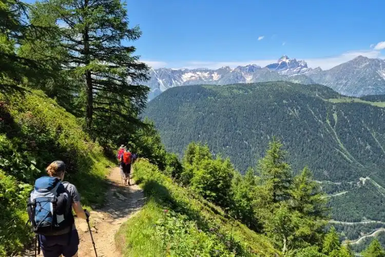Pessoas fazendo trilha na natureza com seguro viagem para prática de esportes