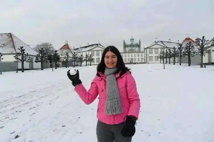 Mulher com bola de neve nas mãos