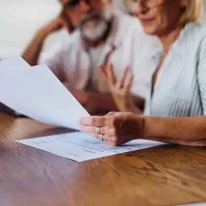 casal olha para documentos na mesa ao fazer documentos para morar na Itália