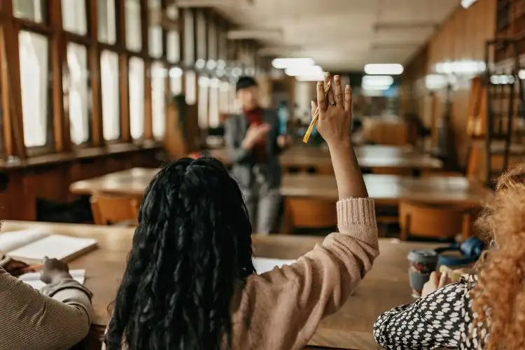 Aluna levantando a mão no curso de inglês na Inlgaterra