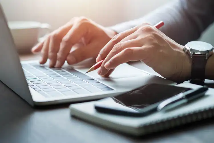 Homem pesquisando e fazendo anotações de sites