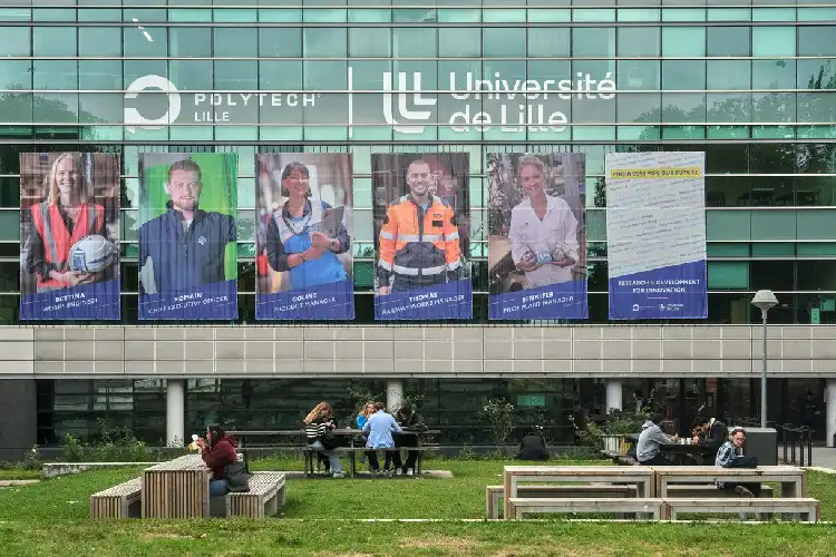 Estudantes sentados na entrada de uma faculdade na França.