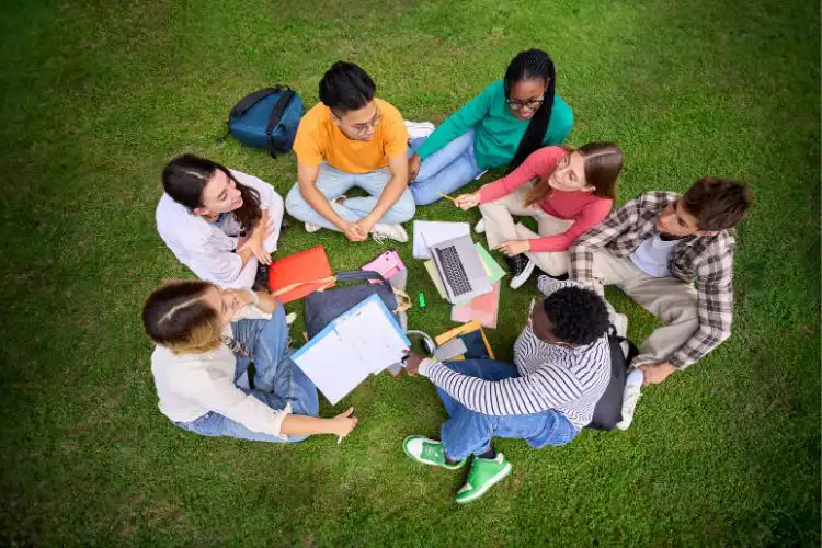 Roda de jovens intercambistas no jardim.