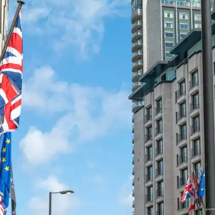 Bandeiras de Reino Unido e União Europeia próximas a um prédio