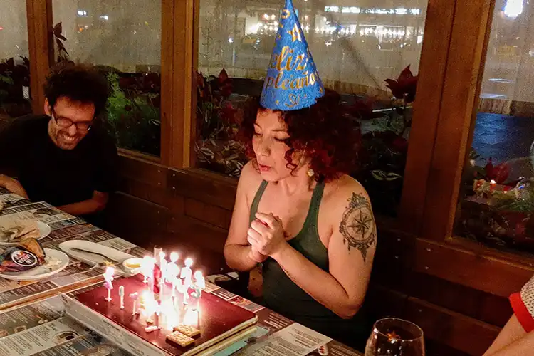 Mulher assopra velas de bolo