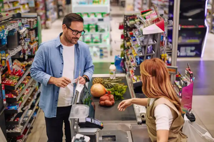 Homem pagando compras no supermercado