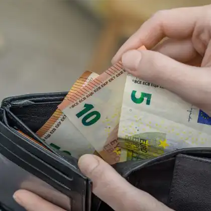 Pessoa contando cédulas de euro, após receber salário mínimo na França.