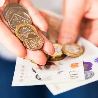 Mulher com salário mínimo na Inglaterra em mãos.