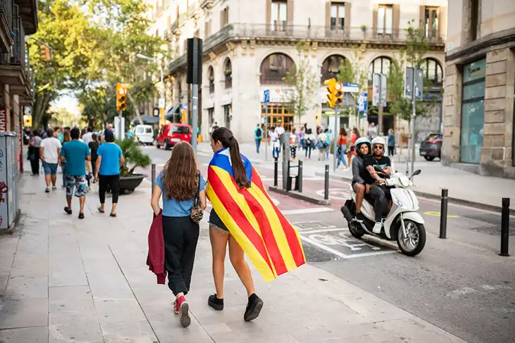 Mulher caminha com uma bandeira da Catalunha em Barcelona