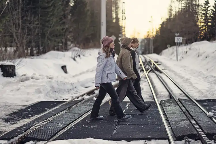 Três amigos andando pelos trilhos nevados na Eslováquia