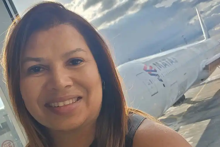 Brasileira Michele Stellmach posa sorridente para foto em aeroporto