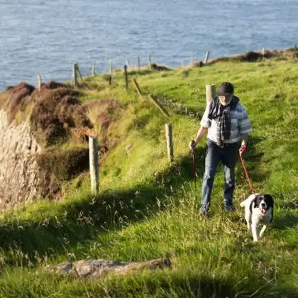 Homem sênior passeando com cachorro na Irlanda