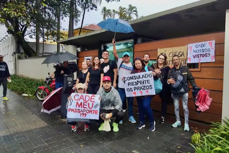 Manifestantes protestam em frente ao Consulado de Portugal com cartazes exigindo vistos e passaportes.