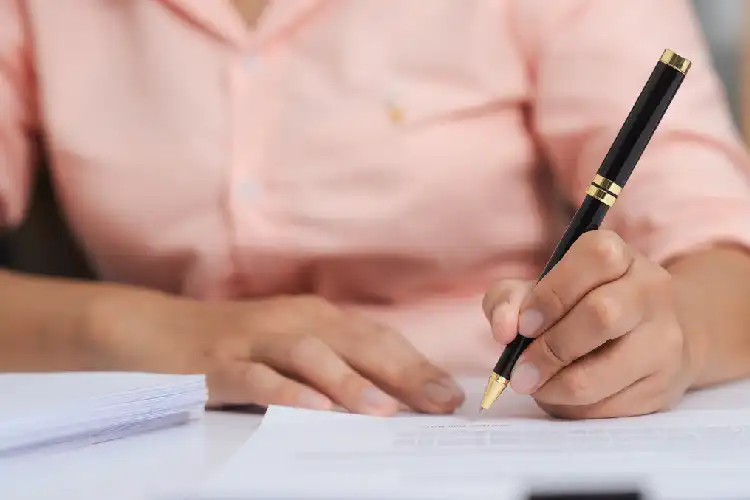 Mulher assinando documentos para a cidadania irlandesa.
