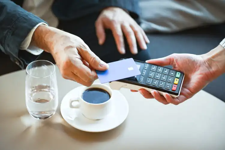 Homem pagando conta com cartão