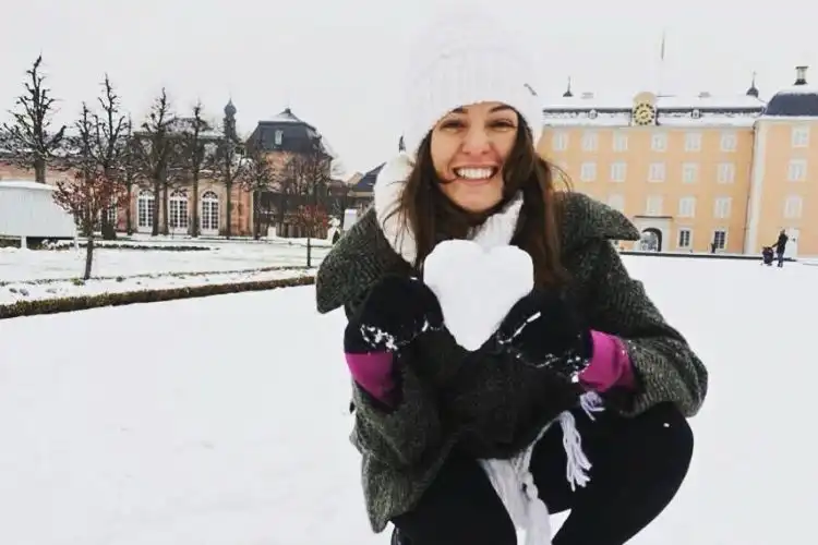 Estudante brasileira sorrindo na neve na Alemanha