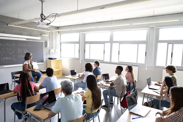 Professora e grupo de alunos estudam em universidade