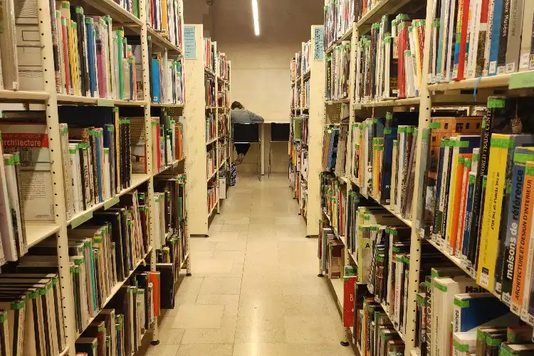 Homem trabalhando sozinho em biblioteca.