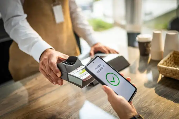 Pessoa realiza pagamento por aproximação usando o celular