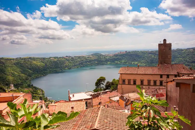 Vista dos Castelli Romani e telhados de casas e lago Albano ao fundo, na região do Lácio, Itália.
