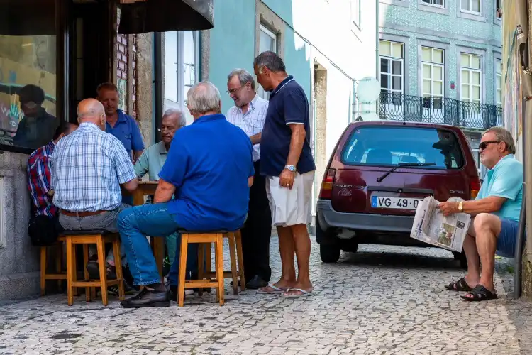 Aposentados reunidos na frente de uma cafeteria de Portugal