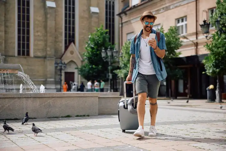 Turista com mala e celular