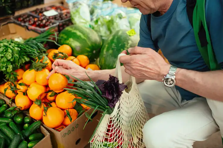 Homem escolhe frutas em feira livre da Itália