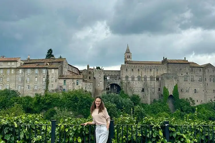 Mulher em Viterbo em frente às muralhas medievais da cidade