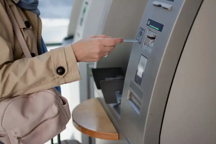 Homem sacando dinheiro do ATM.