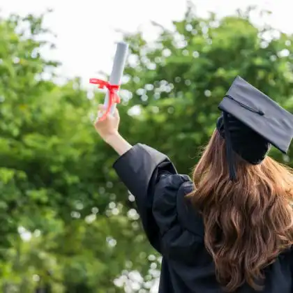 Mulher usando beca celebra a conquista do diploma na Alemanha