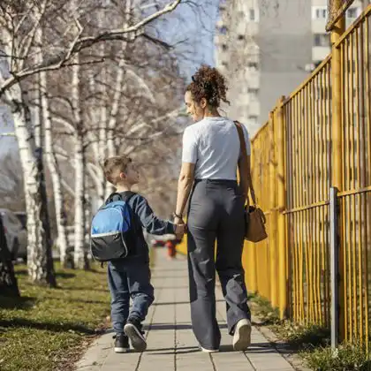 Au Pair e criança caminhando de mãos dadas na volta da escola, na Alemanha