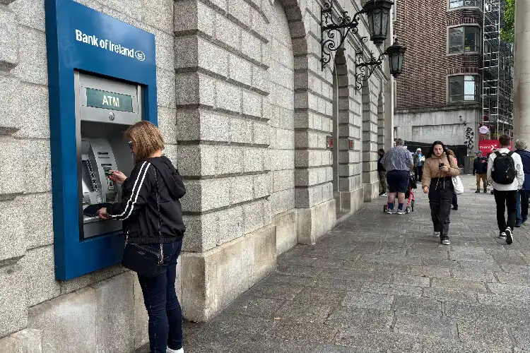 Mulher sacando dinheiro em ATM de banco irlandês.