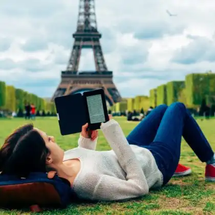 Aluna estuda francês na França, perto da Torre Eiffel.