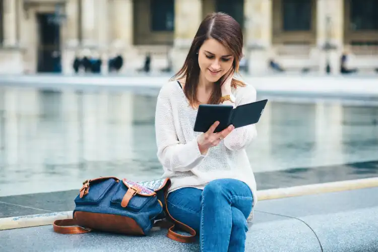 Mulher sentada ao ar livre lendo um livro em uma cidade francesa