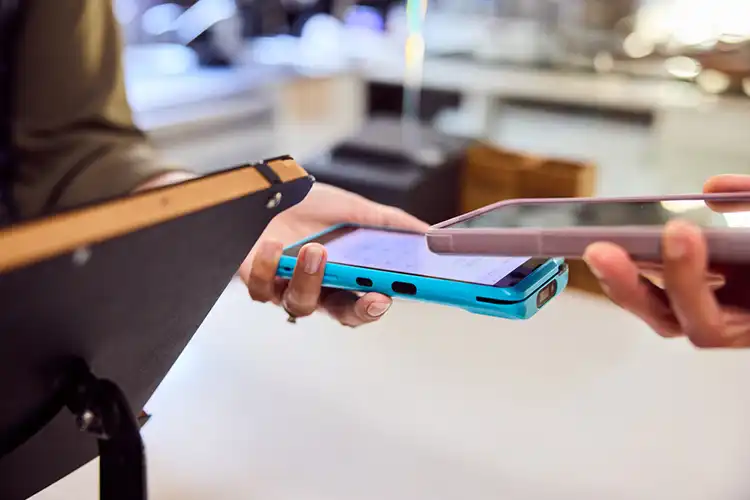 Cliente pagando conta com smartphone por contactless