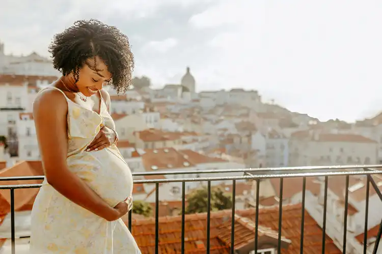 mulher grávida em frente à paisagem de Lisboa
