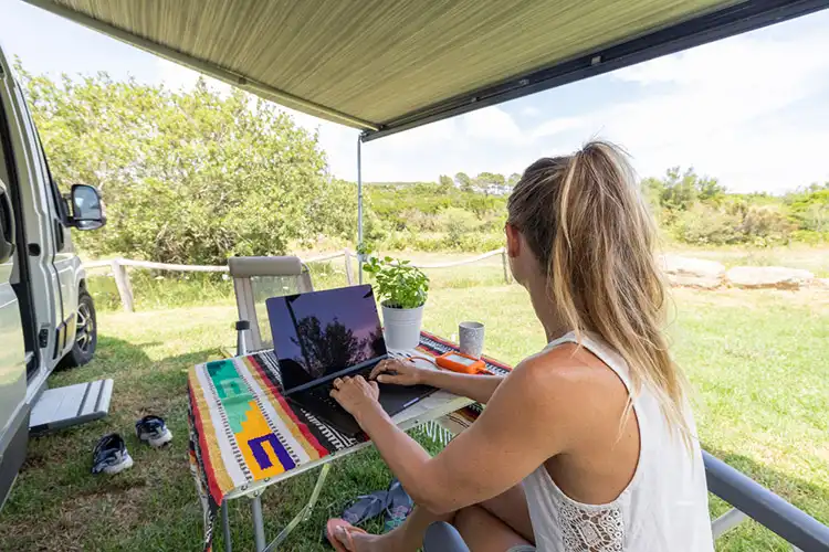 Mulher trabalhando no laptop em camping