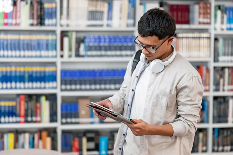 Aluno estudando em biblioteca de universidade