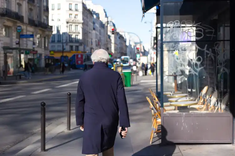 Homem aposentado caminhando por uma cidade da França depois de obter o visto