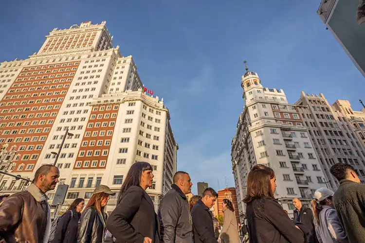 Pessoas atravessando a rua na Plaza de España, em Madrid.