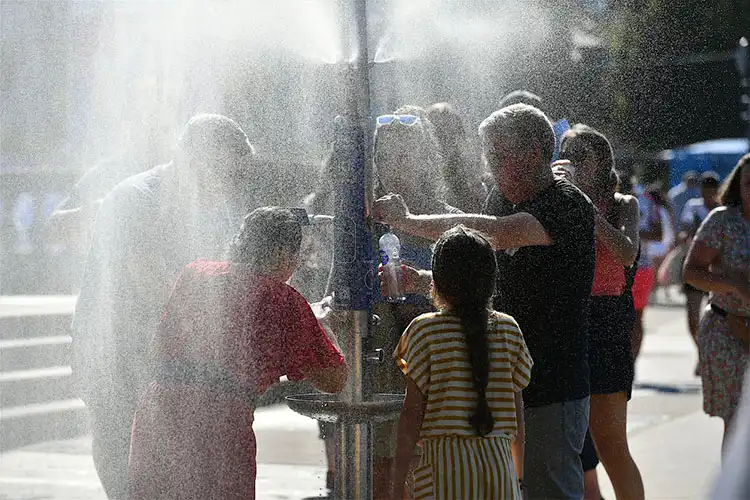 Pessoas se refrescando em fonte de água