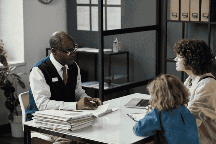 Mãe e filha em reunião com oficial da imigração.