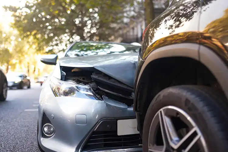 Dois carros amassados após uma colisão em rua da cidade