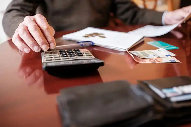 Homem calculando despesas com calculadora