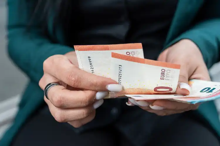 Mulher conta quantos euros tem para viajar.