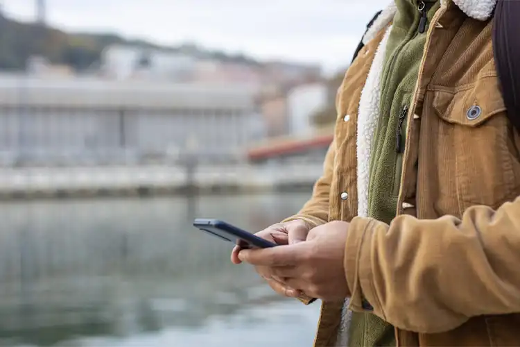 Turista consulta celular perto de ponto turístico europeu