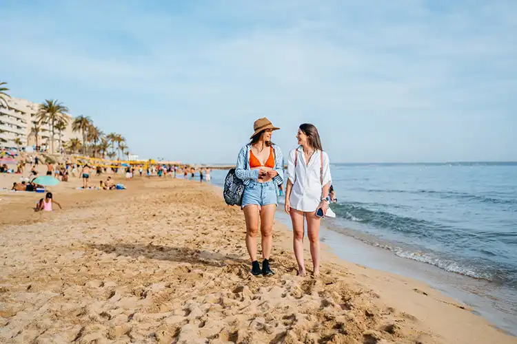 Duas amigas caminhando na praia em Palma de Maiorca, na Espanha