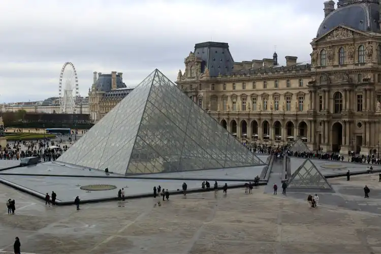 Área externa do Museu do Louvre com turistas e locais ao redor