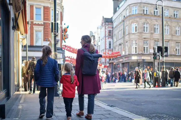 Mulher com pre-settled caminhando com filhas na Inglaterra