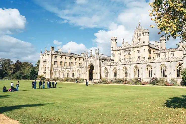 Estudantes na entrada da Universidade de Cambridge.